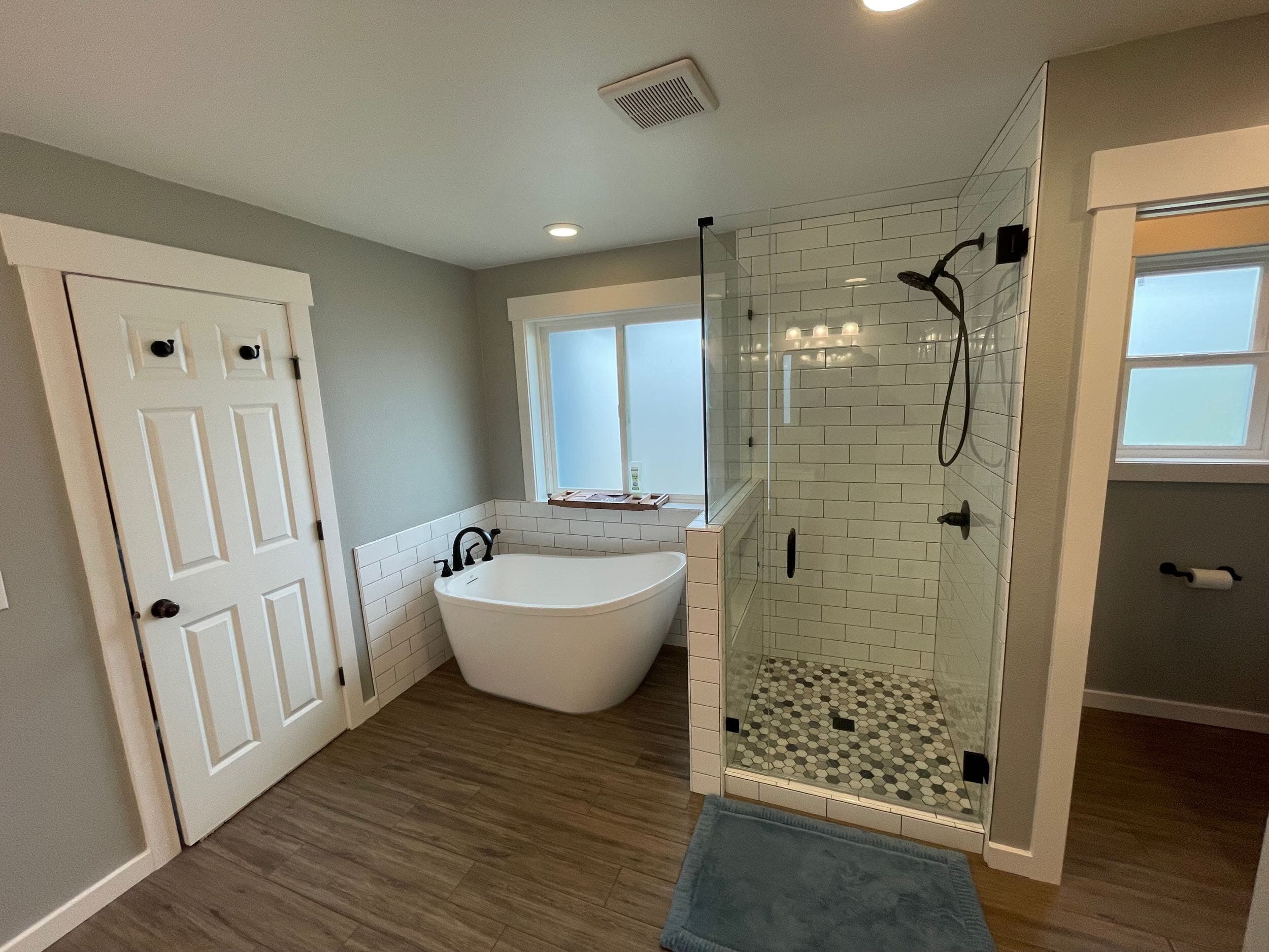 Shower Reference — Bathroom remodel with freestanding tub, glass shower with mosaic tile pan, and subway-tile walls