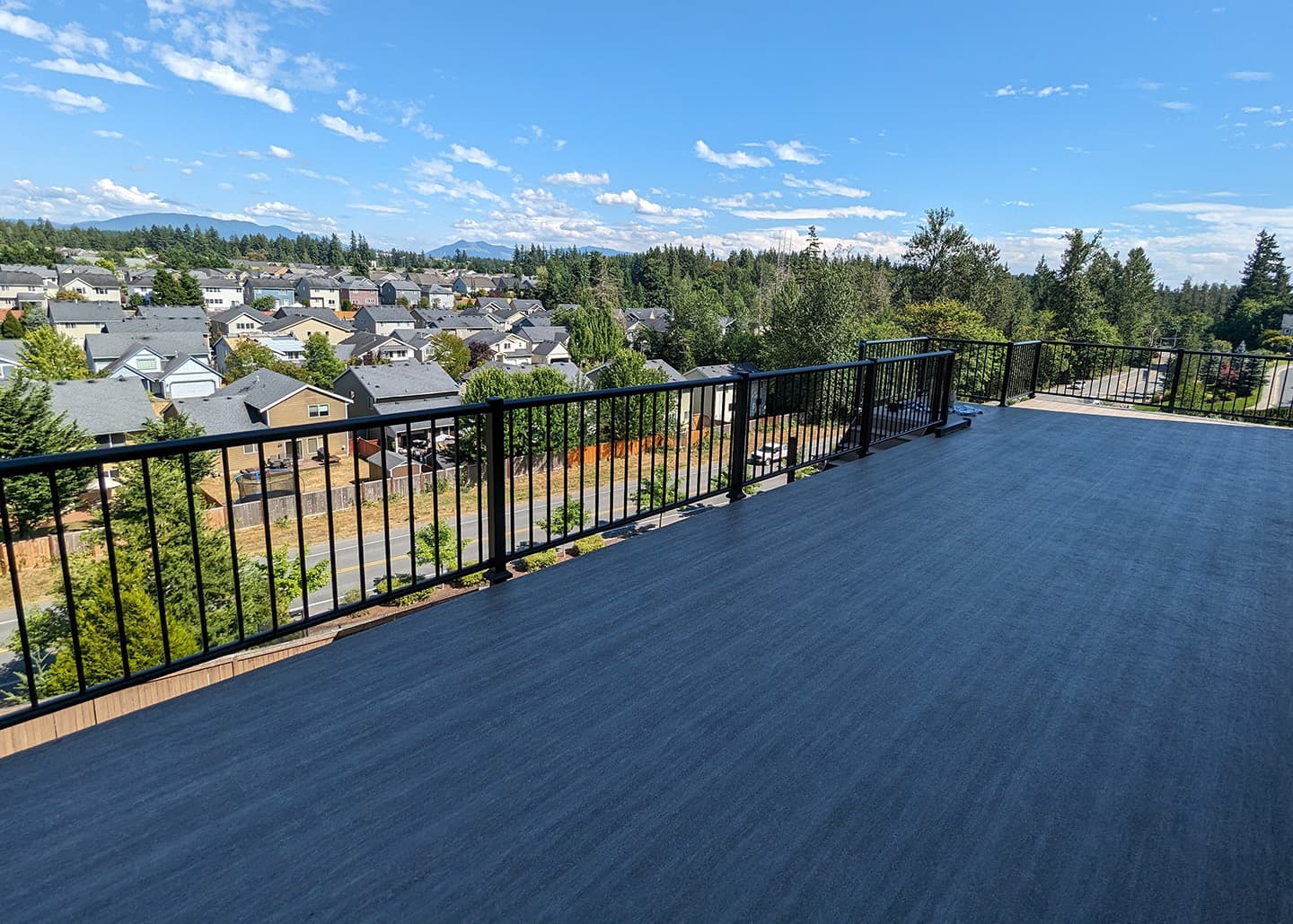Finished deck with black railings and an open neighborhood view