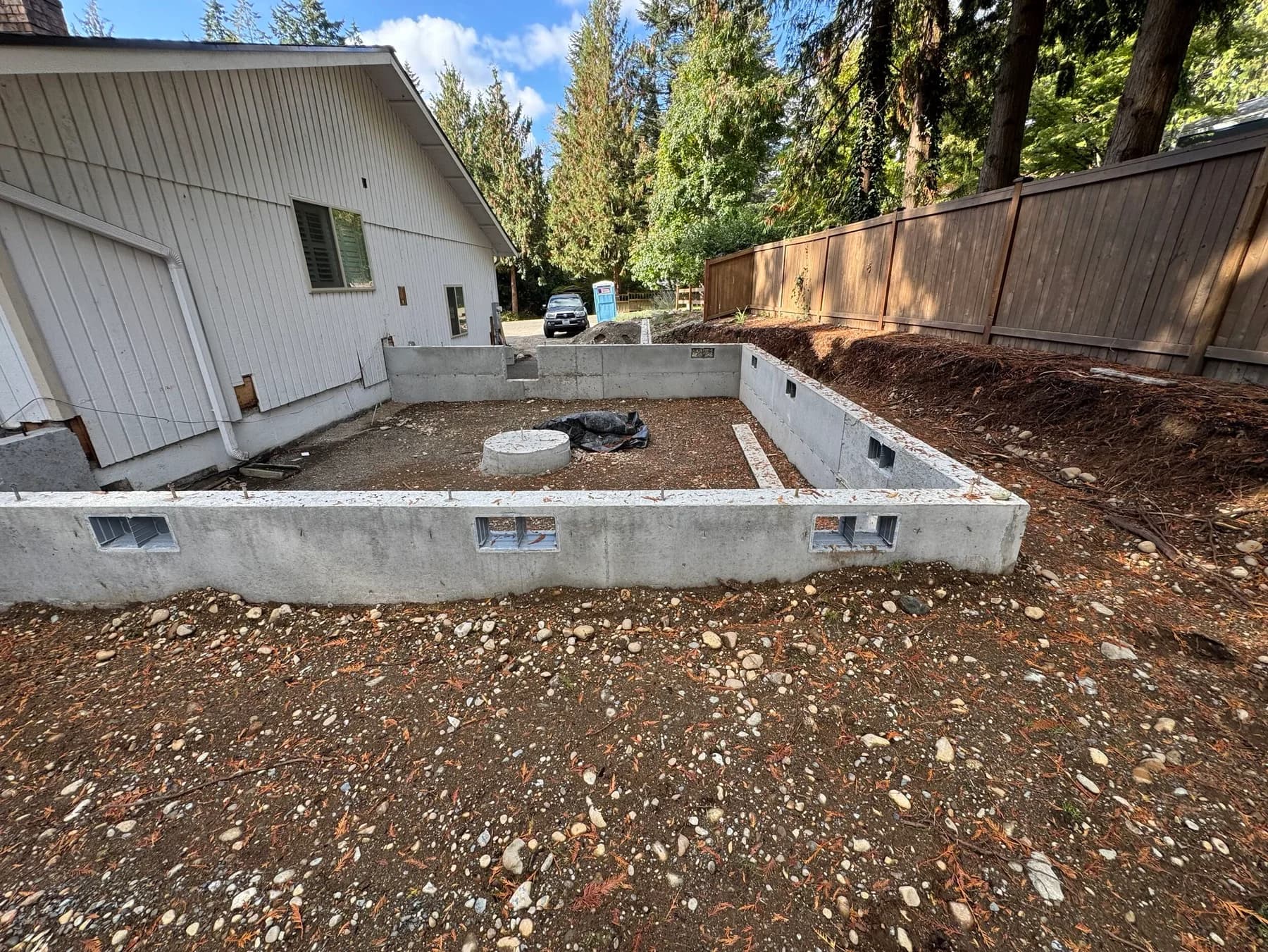 Home Additions — Concrete foundation walls for a residential addition beside an existing home