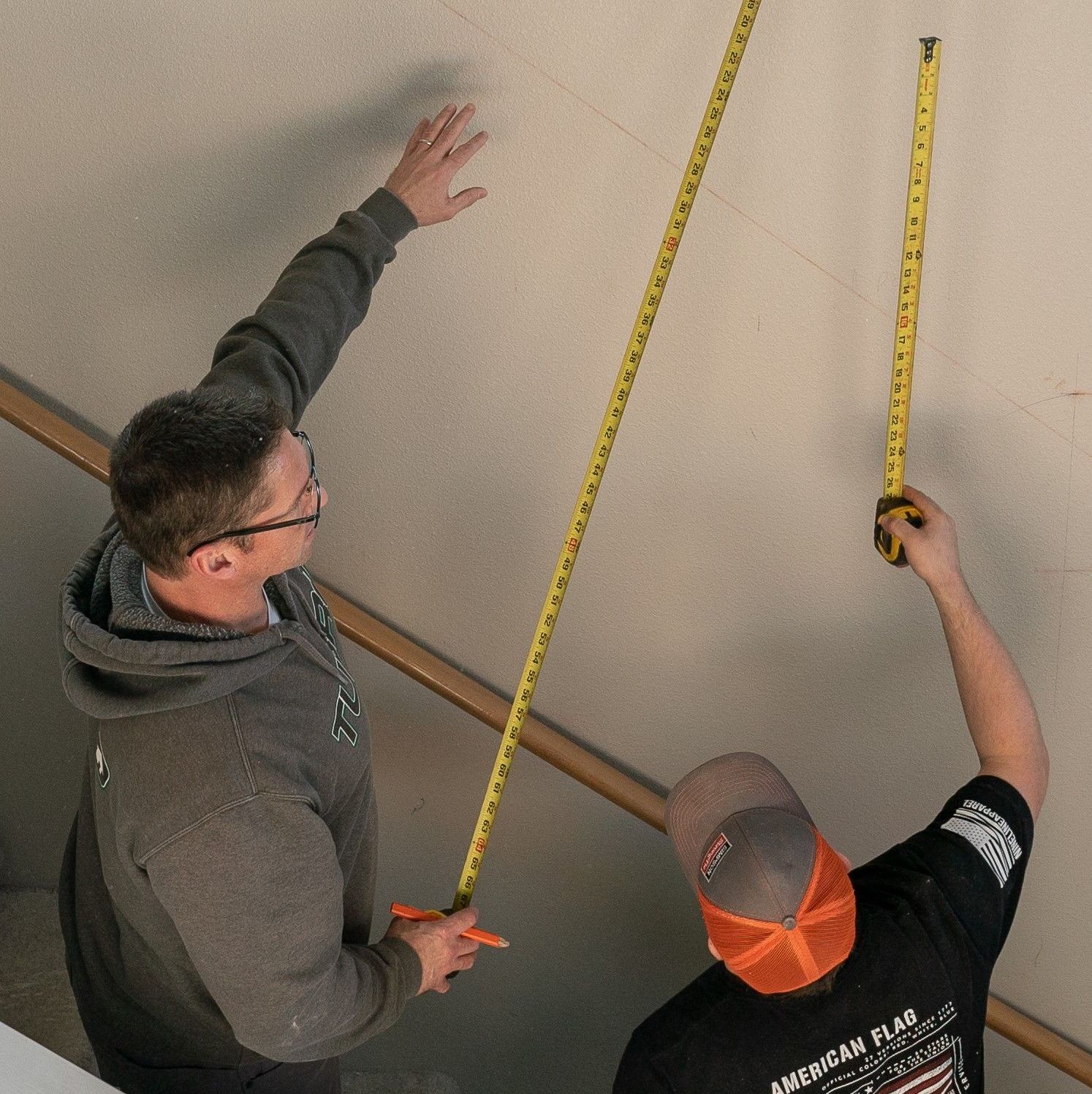 2(two) Tubro workers measuring the wall for renovation